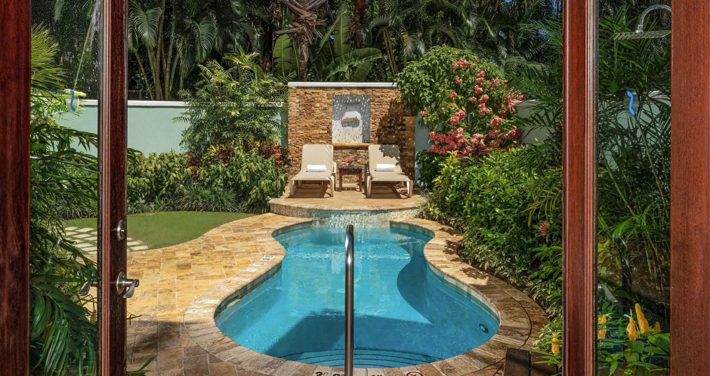 Private plunge pool and loungers framed by open doors at Sandals Negril.