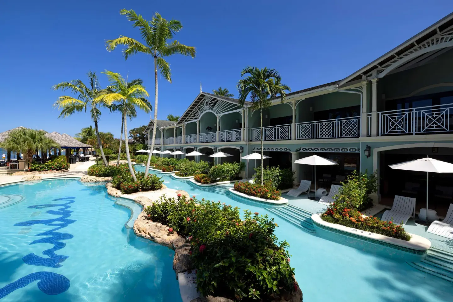 Swim-up pool beside tropical gardens and balconies at Sandals Negril.