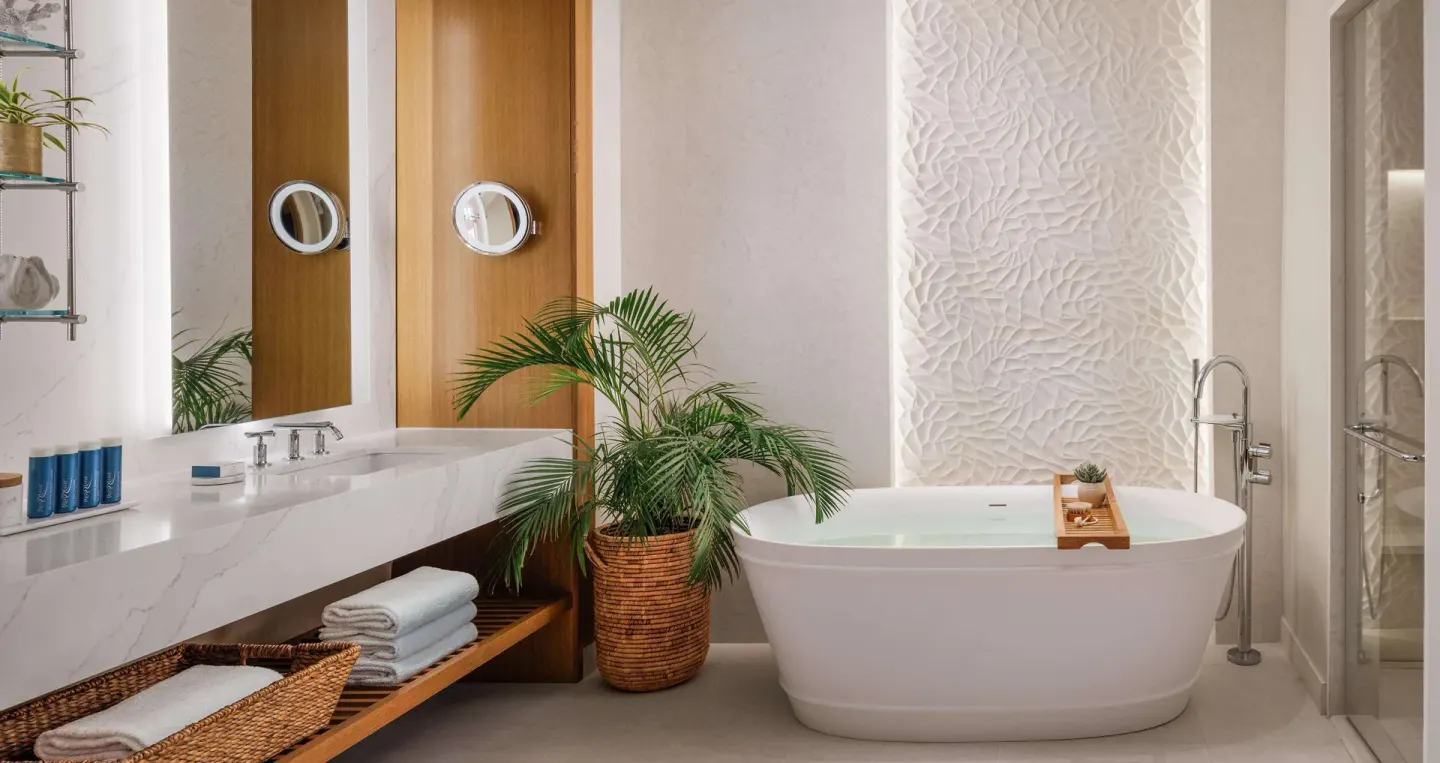 Freestanding tub and vanity in a Bamboo Grove Skypool suite bathroom at Sandals Negril.