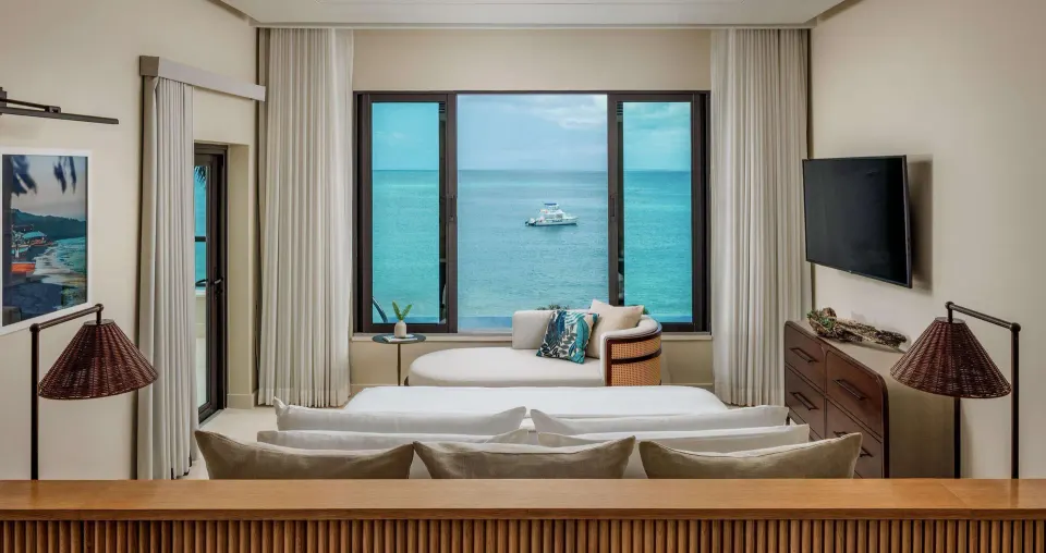 King bed facing ocean-view windows in a Bamboo Grove Skypool suite at Sandals Negril.