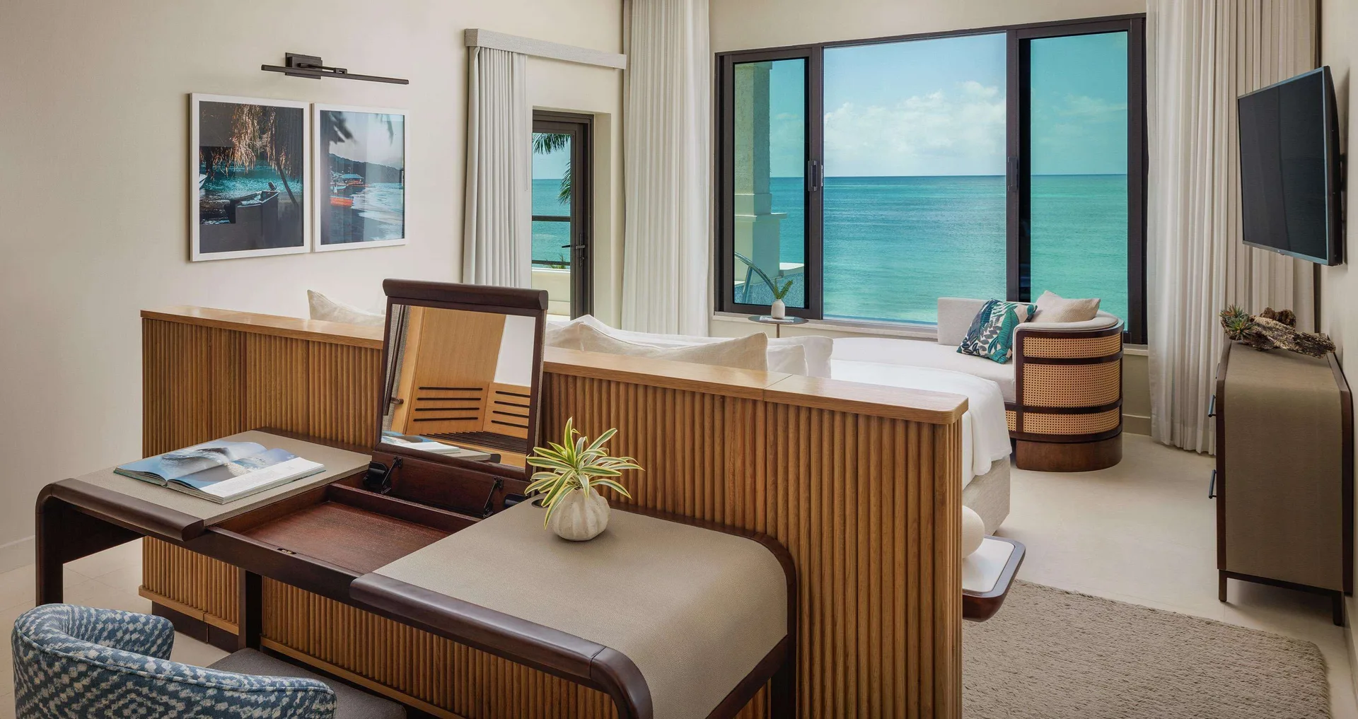 Oceanfront bedroom and desk area in a Bamboo Grove Skypool suite at Sandals Negril.