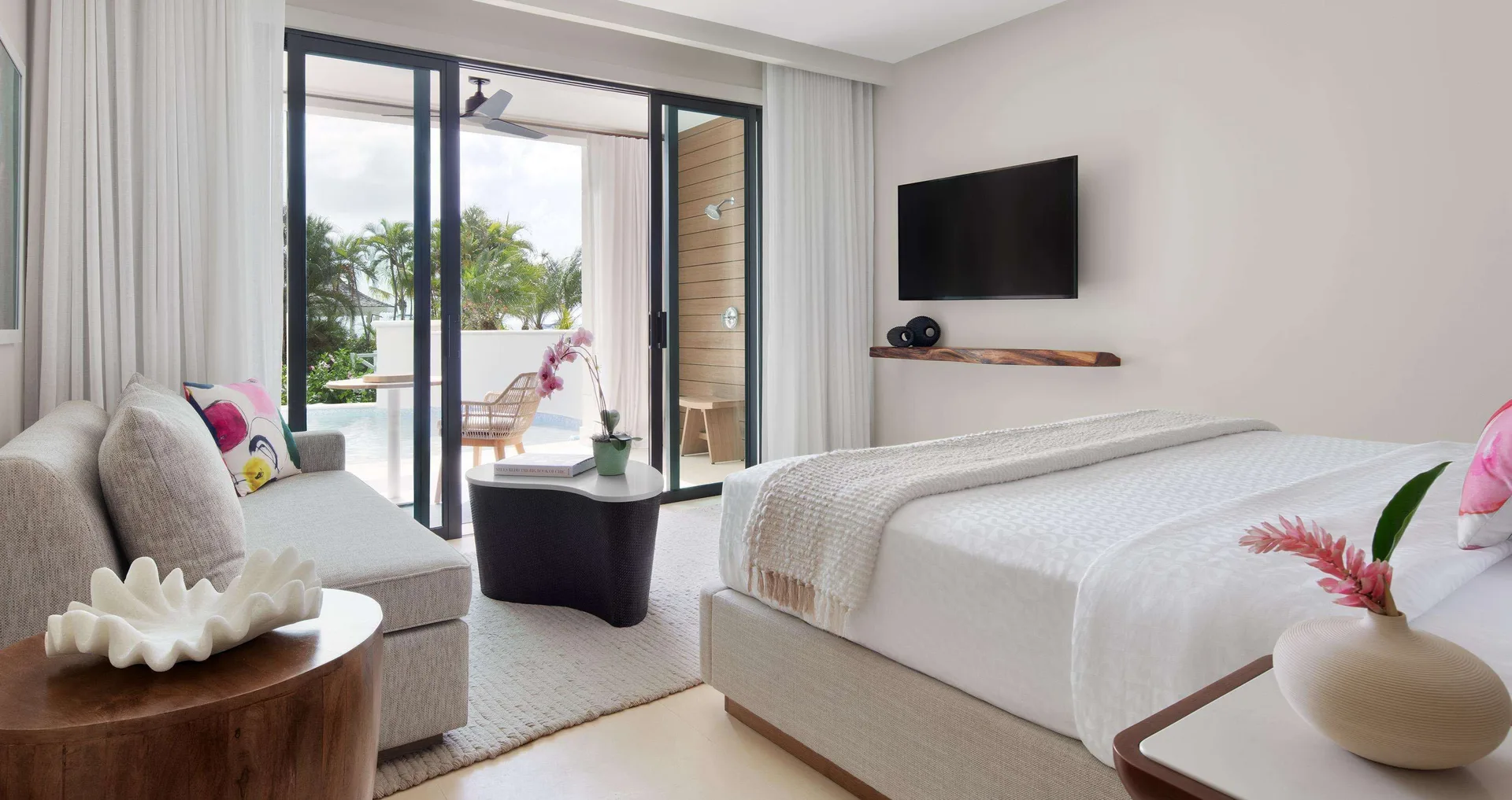 Bamboo Grove Swim-up Club Suite king bed, sofa and terrace doors at Sandals Negril.