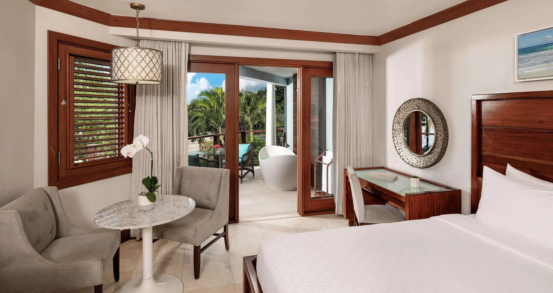 King bedroom with balcony soaking tub outside at Sandals Negril.
