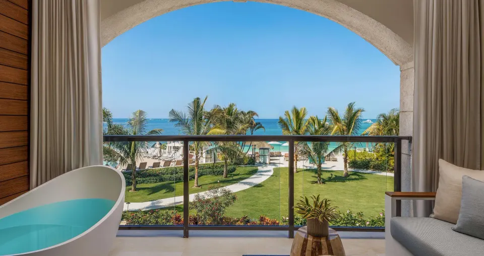 Balcony soaking tub with ocean and palm garden view at Sandals Negril.