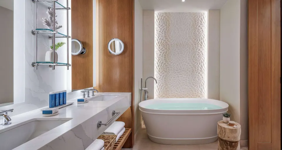 Bathroom soaking tub and double vanity in a Longshore Beachfront room at Sandals Negril.