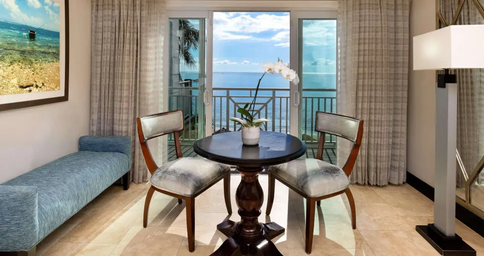 Beachfront Club Level room sitting area with ocean-view balcony at Sandals Negril.
