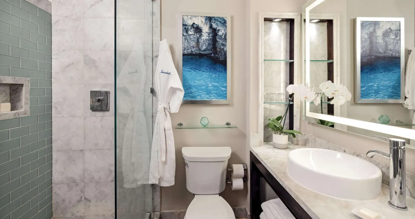 Paradise Deluxe bathroom with glass shower and vessel sink at Sandals Negril.