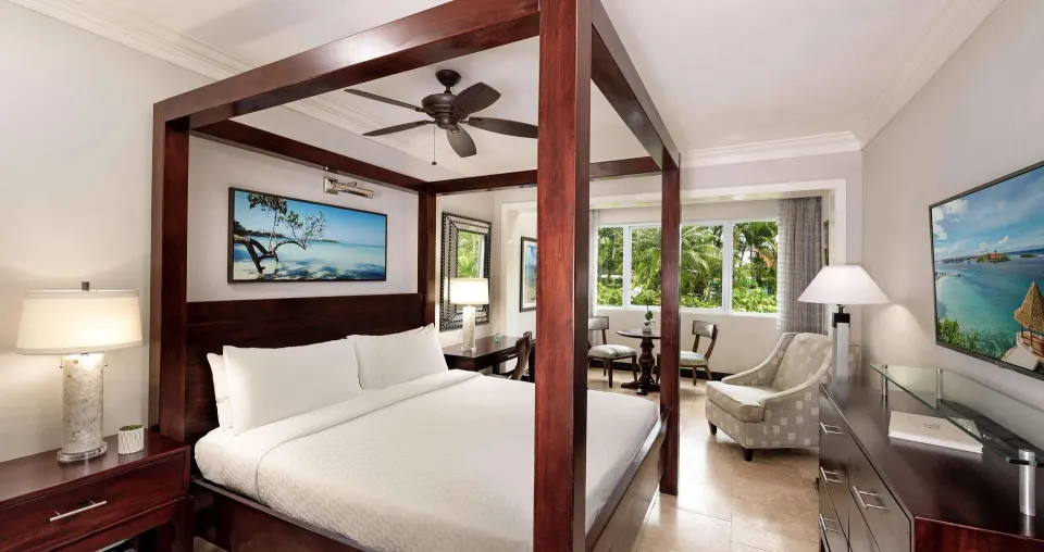 Paradise Deluxe guest room with four-poster king bed at Sandals Negril.
