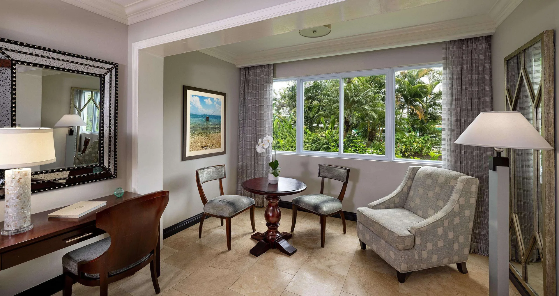 Paradise Deluxe sitting area with desk and garden-facing windows at Sandals Negril.
