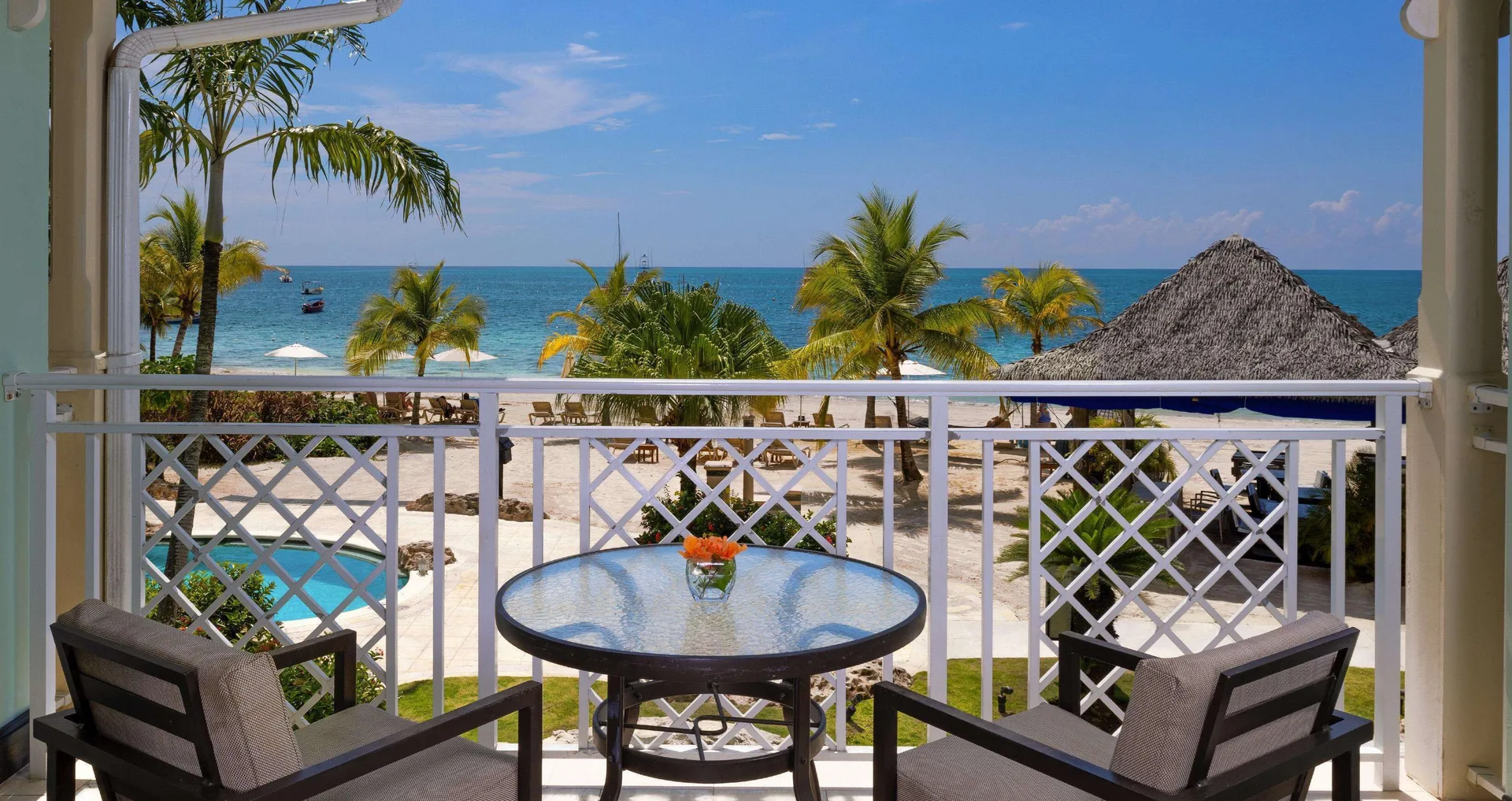Beachfront balcony with chairs and ocean view at Sandals Negril.