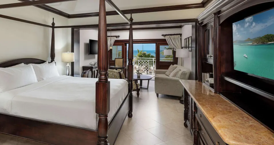 Four-poster king bed and ocean-facing suite interior at Sandals Negril.