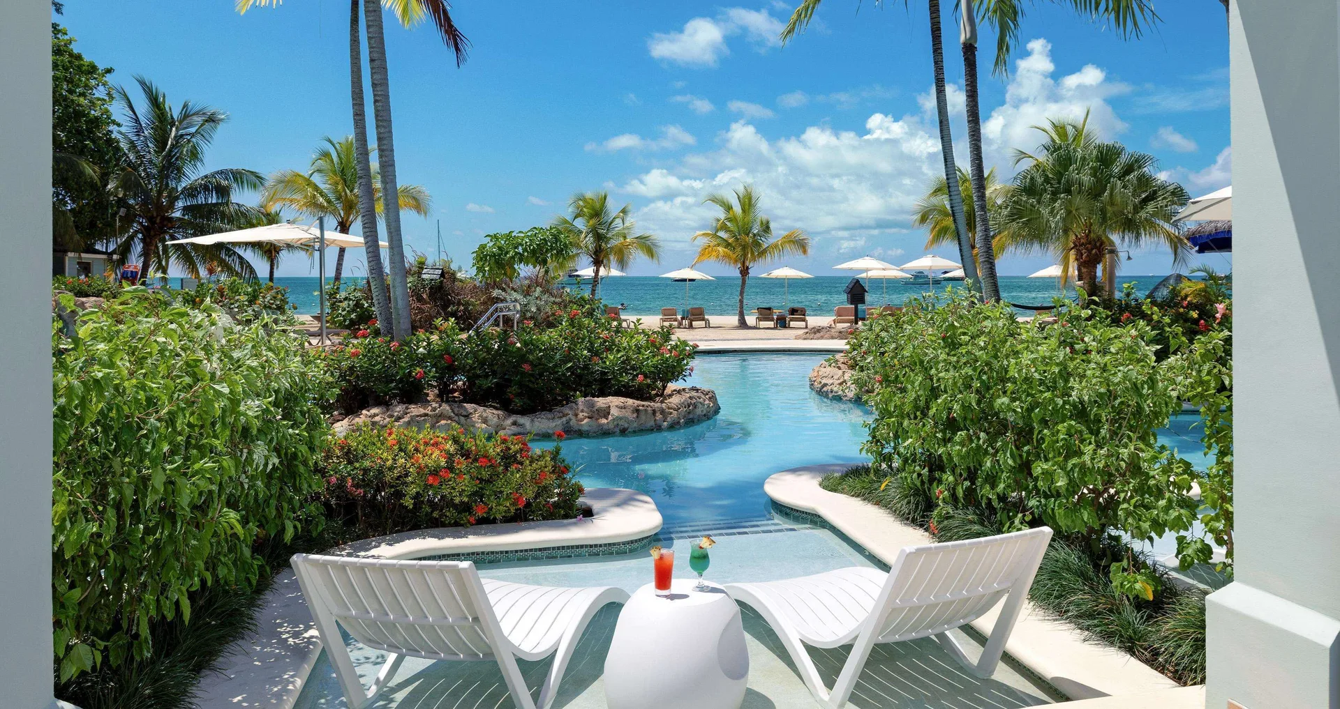 Sundowner Swim Up Beachfront One Bedroom Butler Suite patio at Sandals Negril with pool and beach beyond.