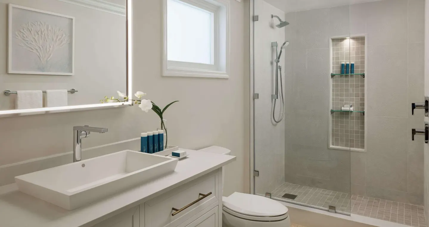Modern bathroom with vanity and glass-enclosed shower at Sandals Ochi.
