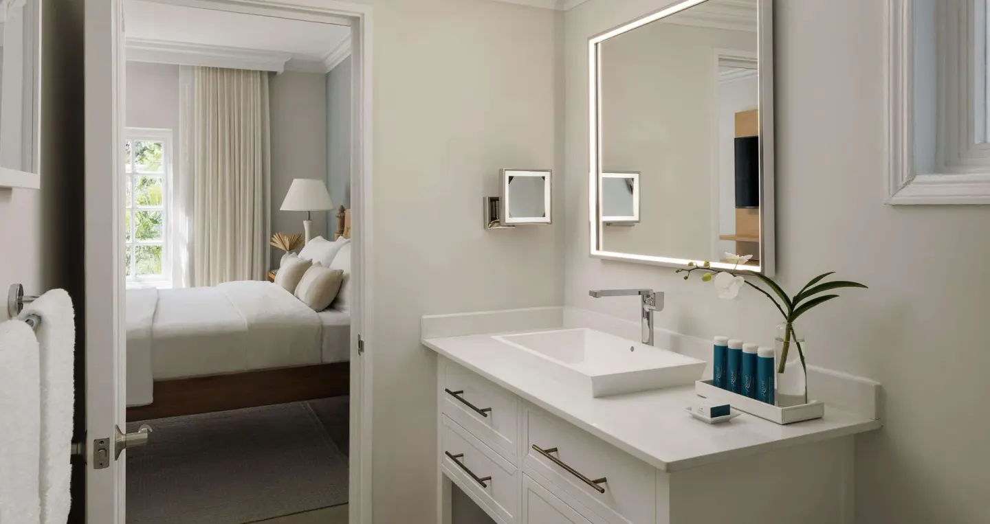 Bathroom vanity with a view into the bedroom and king bed at Sandals Ochi.