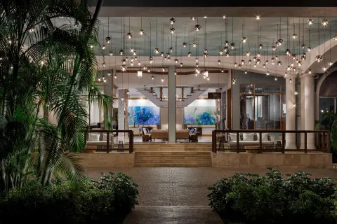 Evening exterior view of the illuminated lobby entrance at Sandals Ochi.