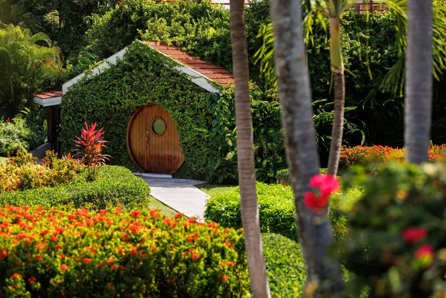 Ivy-covered garden cottage with round wooden door at Sandals Ochi.