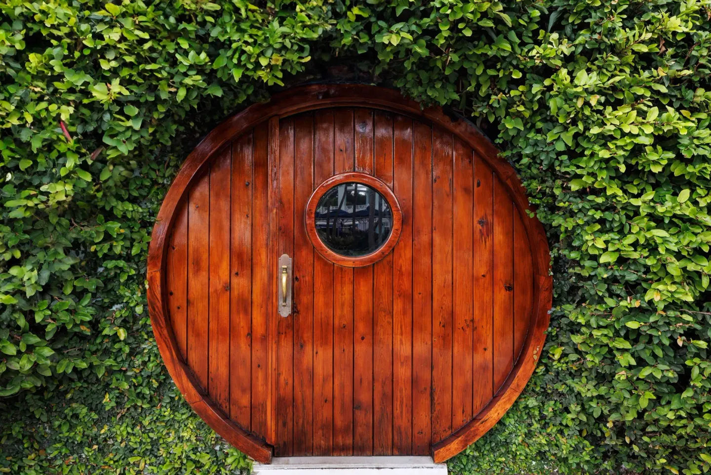 Round wooden door set into a wall of greenery at Sandals Ochi.