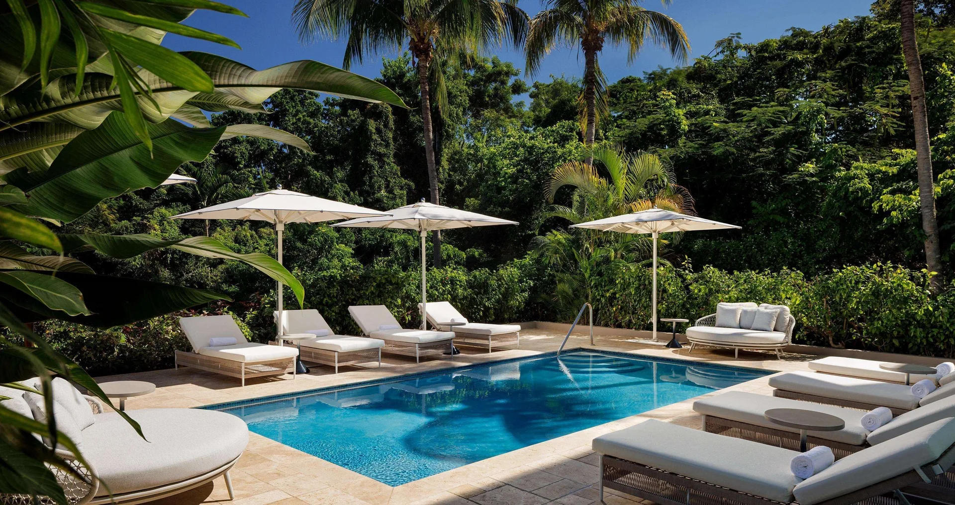 Secluded pool terrace with loungers and umbrellas at Sandals Ochi.