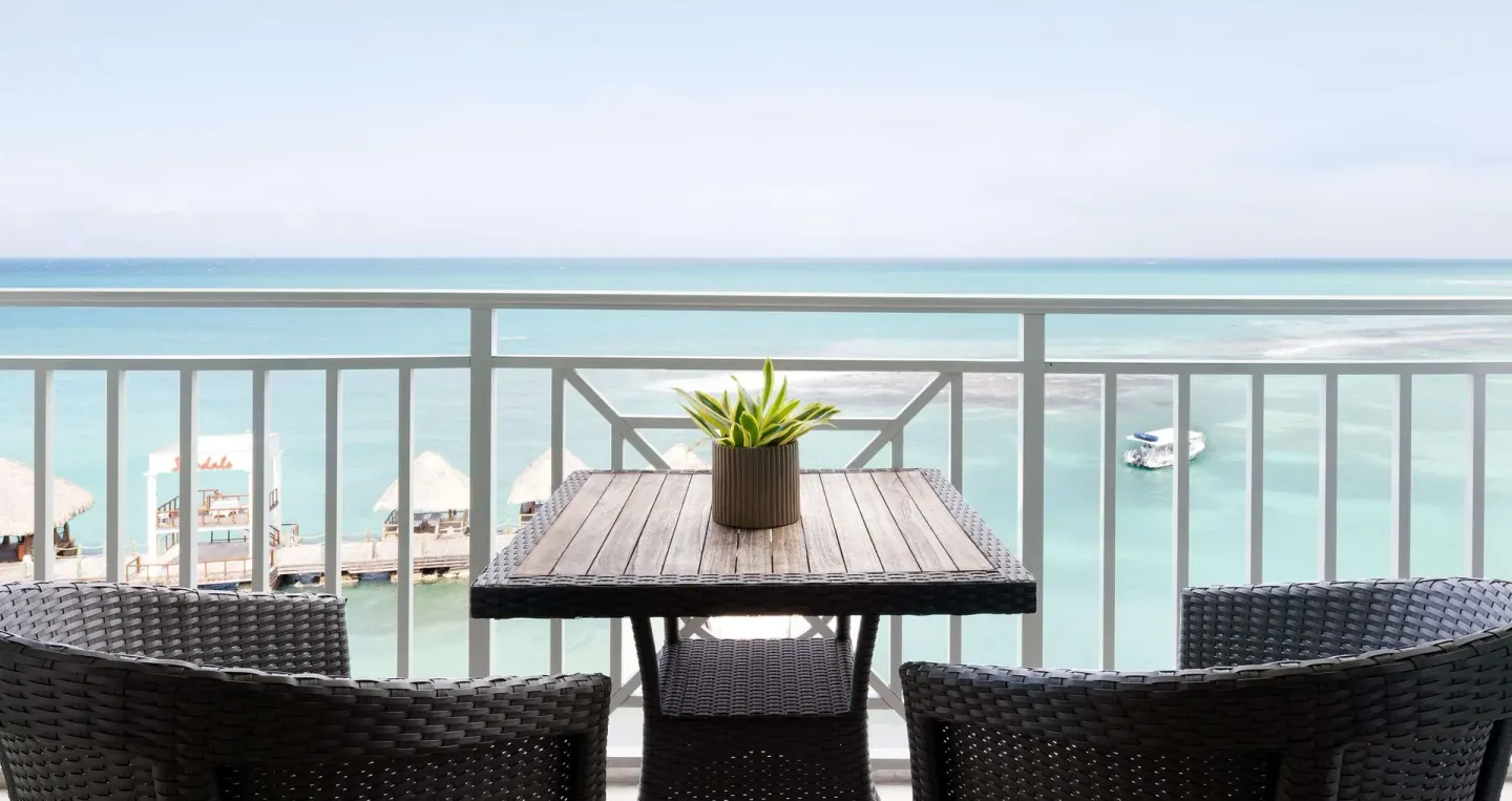Ocean-view balcony seating at the Club Penthouse room at Sandals Ochi.