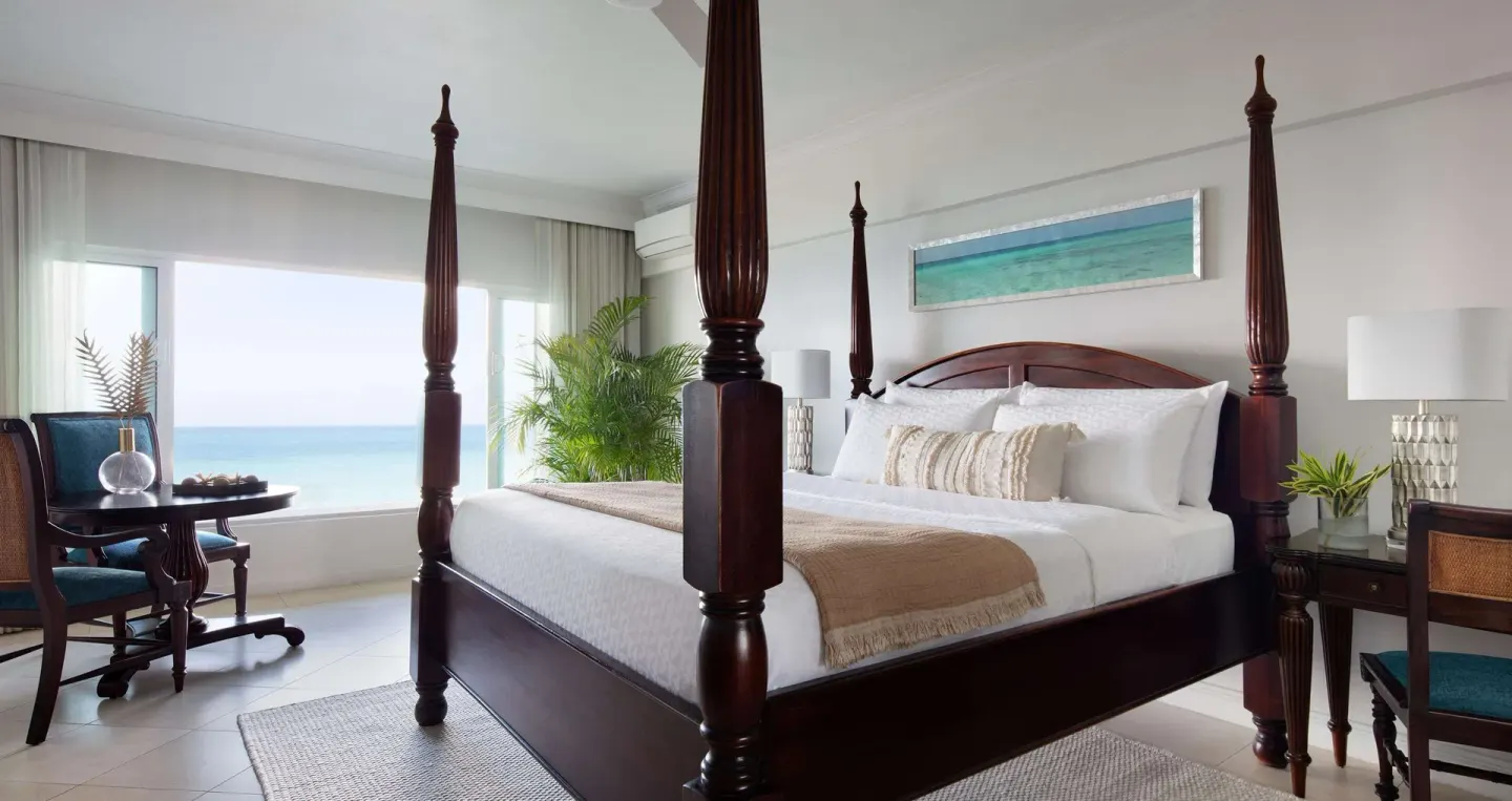 Club ocean view room with four-poster king bed at Sandals Ochi.