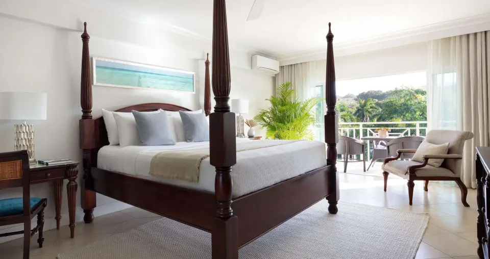 Deluxe room with four-poster bed and balcony at Sandals Ochi.