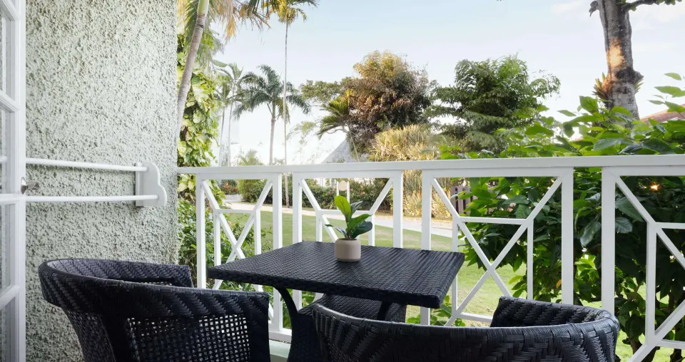 Garden balcony seating for a Honeymoon Cottage Garden View room at Sandals Ochi.