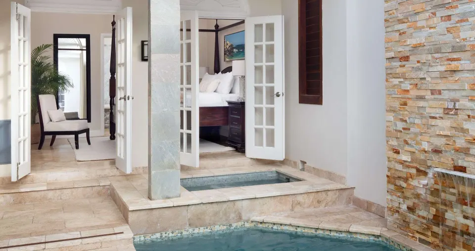 Private pool patio beside the villa bedroom with king bed at Sandals Ochi.