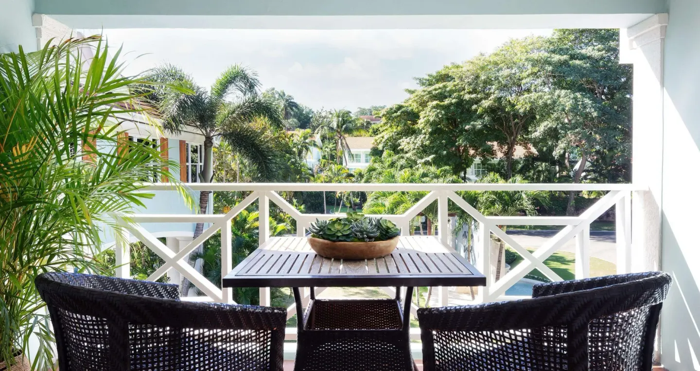 Luxury Room balcony seating with garden view at Sandals Ochi.