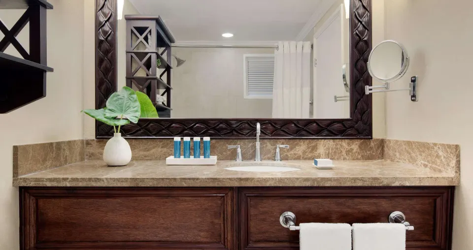 Luxury room bathroom vanity with marble counter and mirror at Sandals Ochi.
