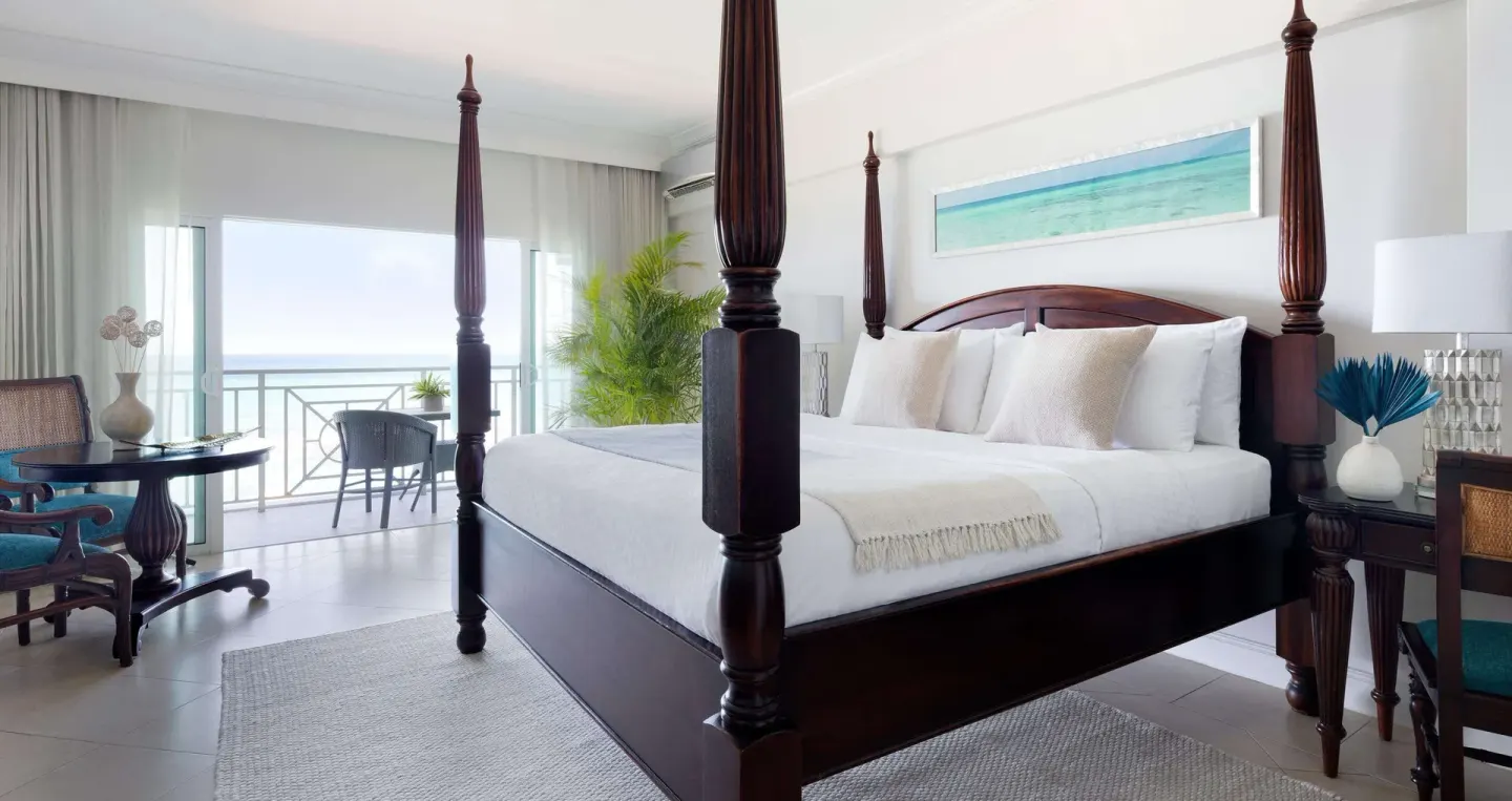 Luxury room king four-poster bed with balcony doors at Sandals Ochi.