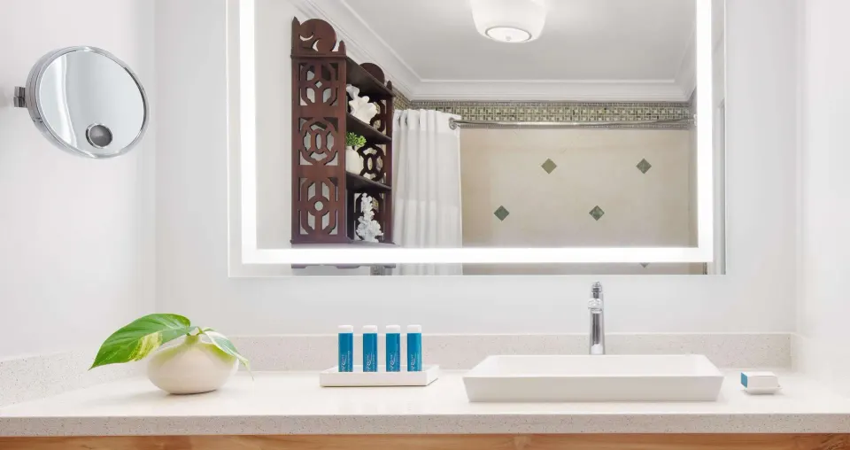 Bathroom vanity in a Luxury Room at Sandals Ochi with vessel sink, mirror, and bath amenities.