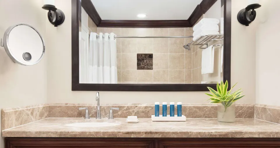 Bathroom vanity in a Premium Garden View room at Sandals Ochi with mirror, towels, and amenities.