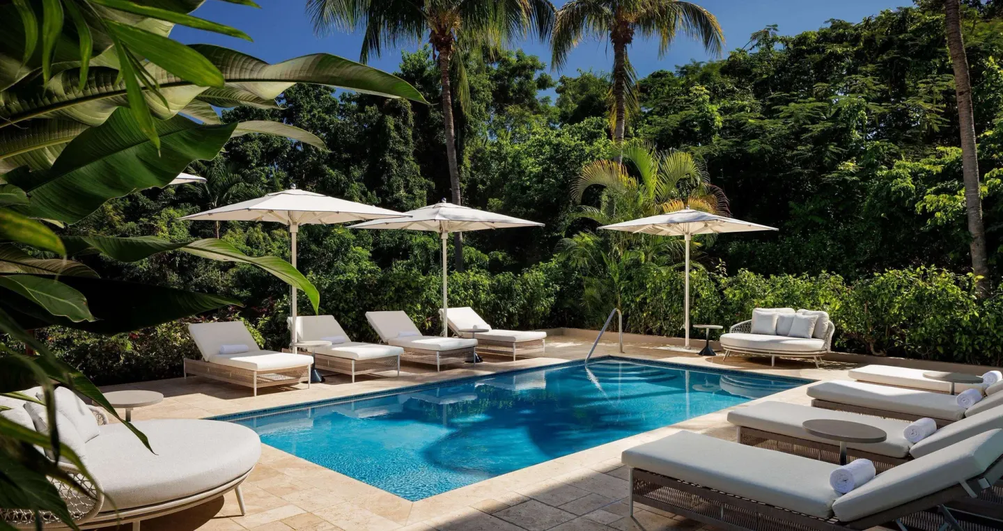 Garden pool with loungers and umbrellas at Sandals Ochi.