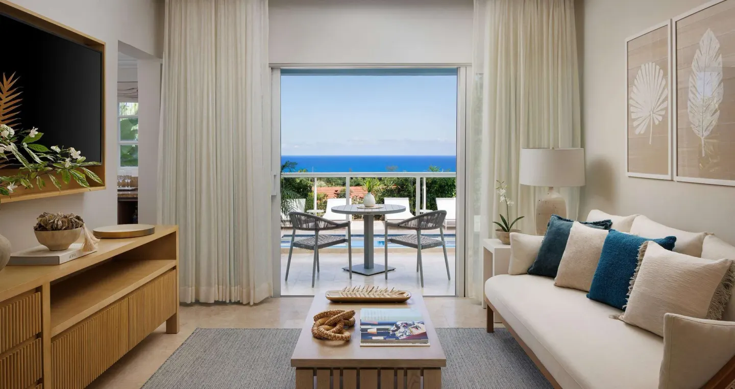 Living room opening to a poolside ocean-view terrace at Sandals Ochi.