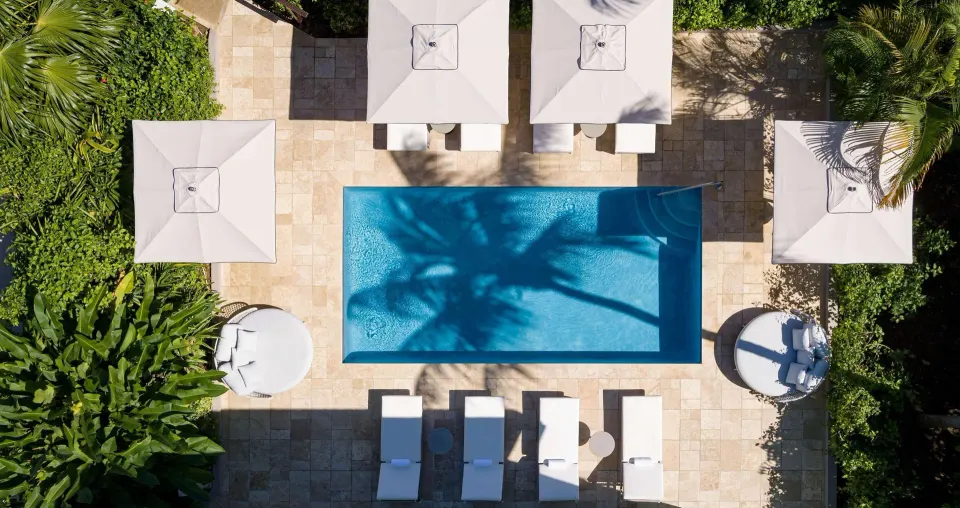 Top-down view of a villa pool with loungers and umbrellas at Sandals Ochi.