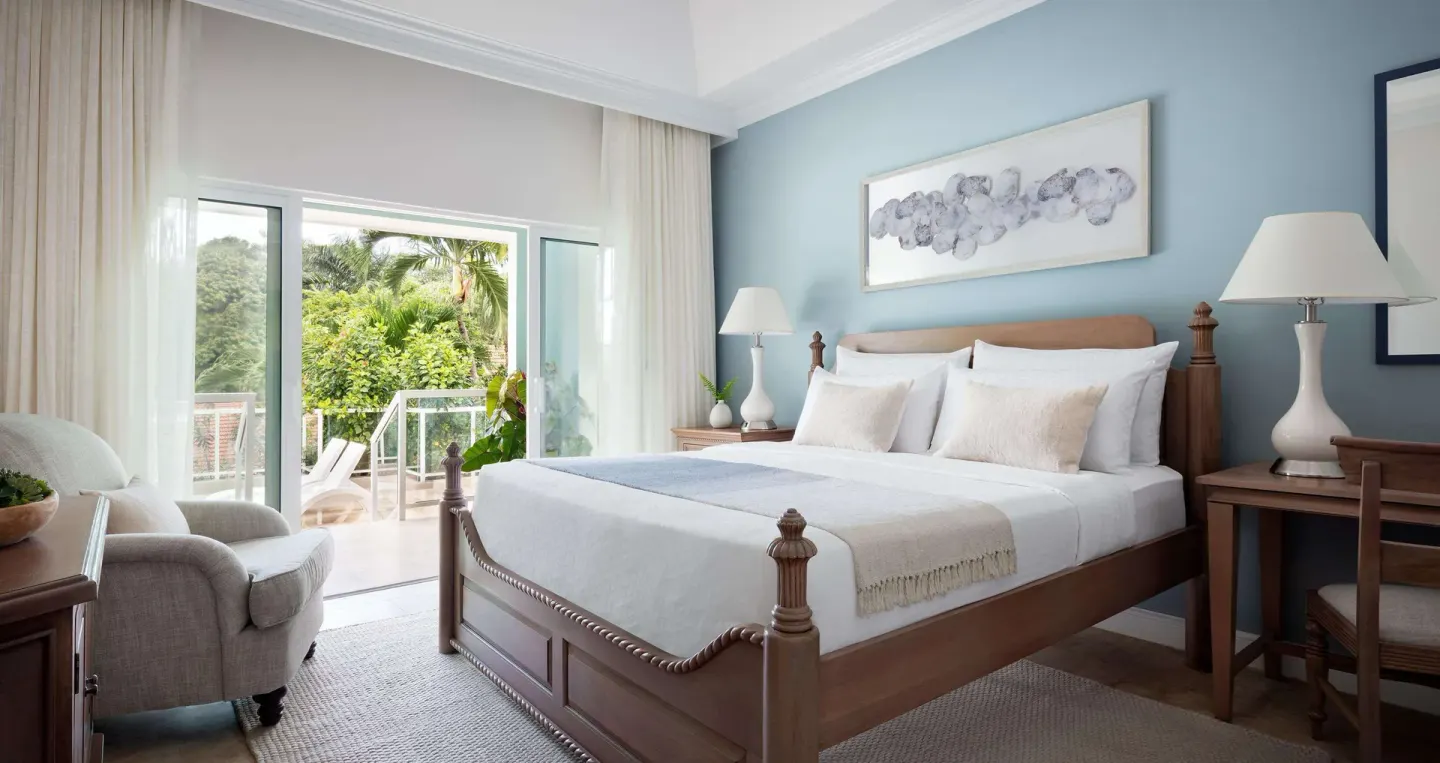 Poolside butler estate suite bedroom with balcony at Sandals Ochi.