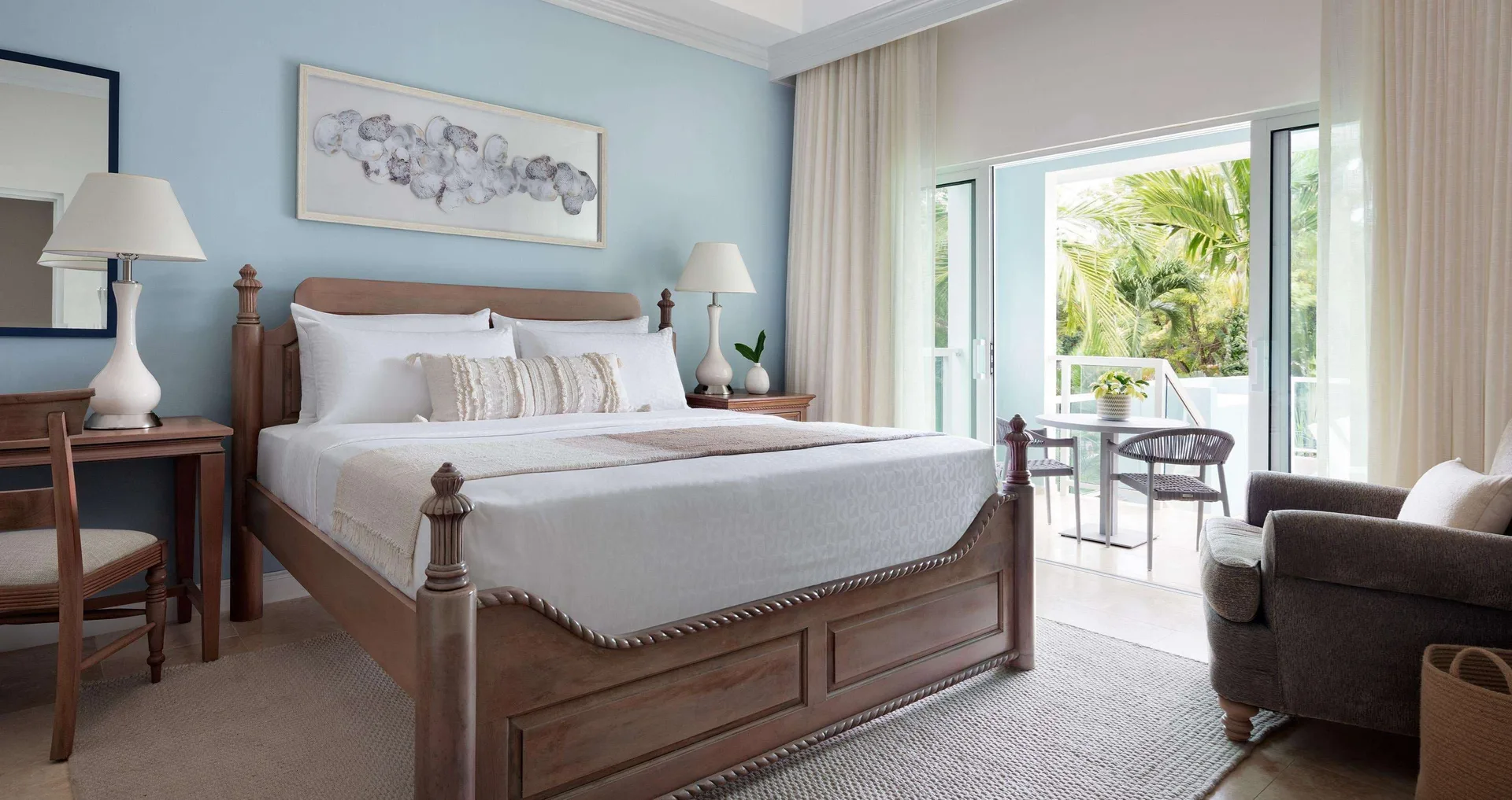 King bed and balcony seating in a villa poolside Club Level room at Sandals Ochi.