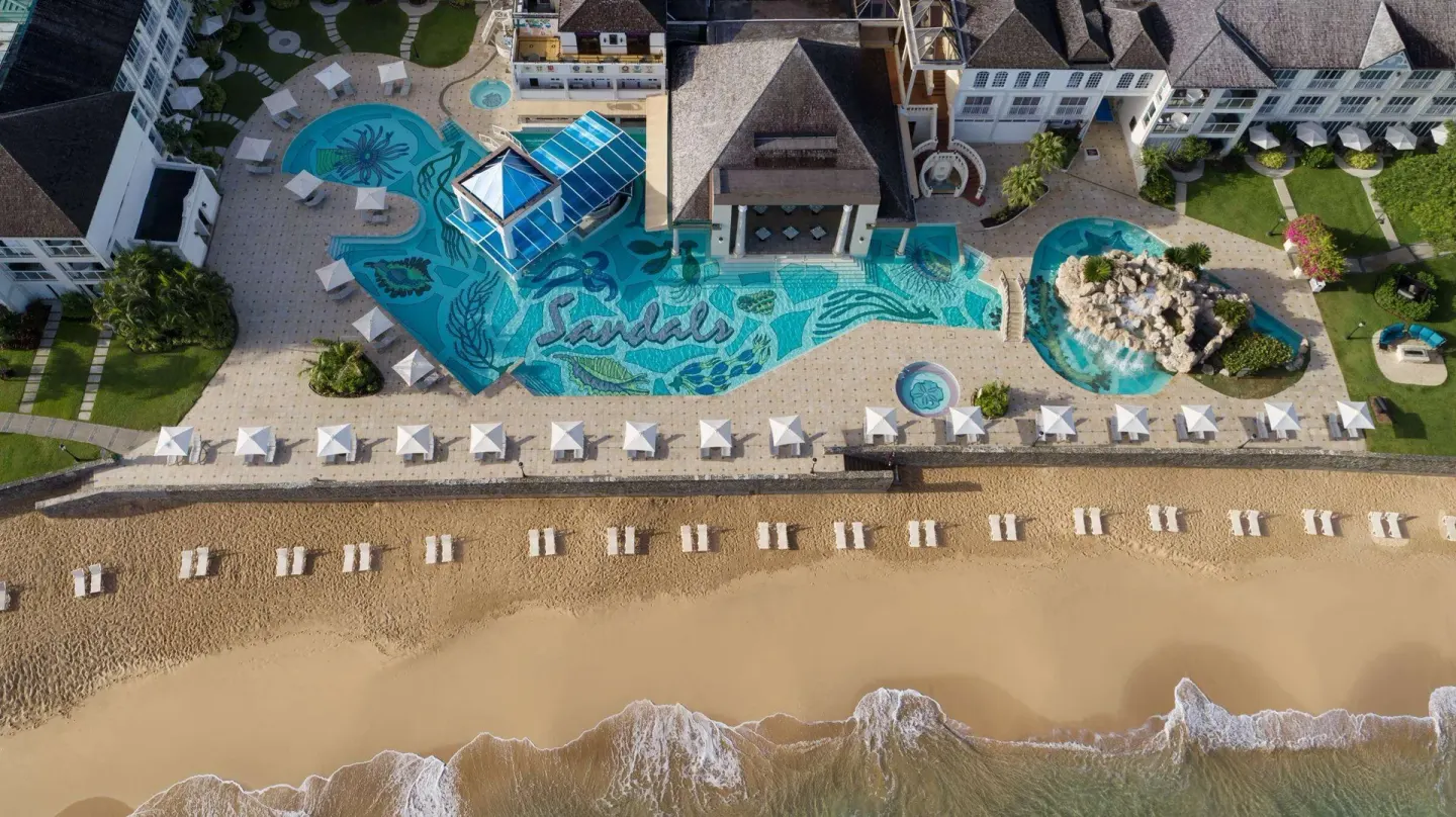 Aerial view of the beachfront pool complex and beach at Sandals Regency La Toc.
