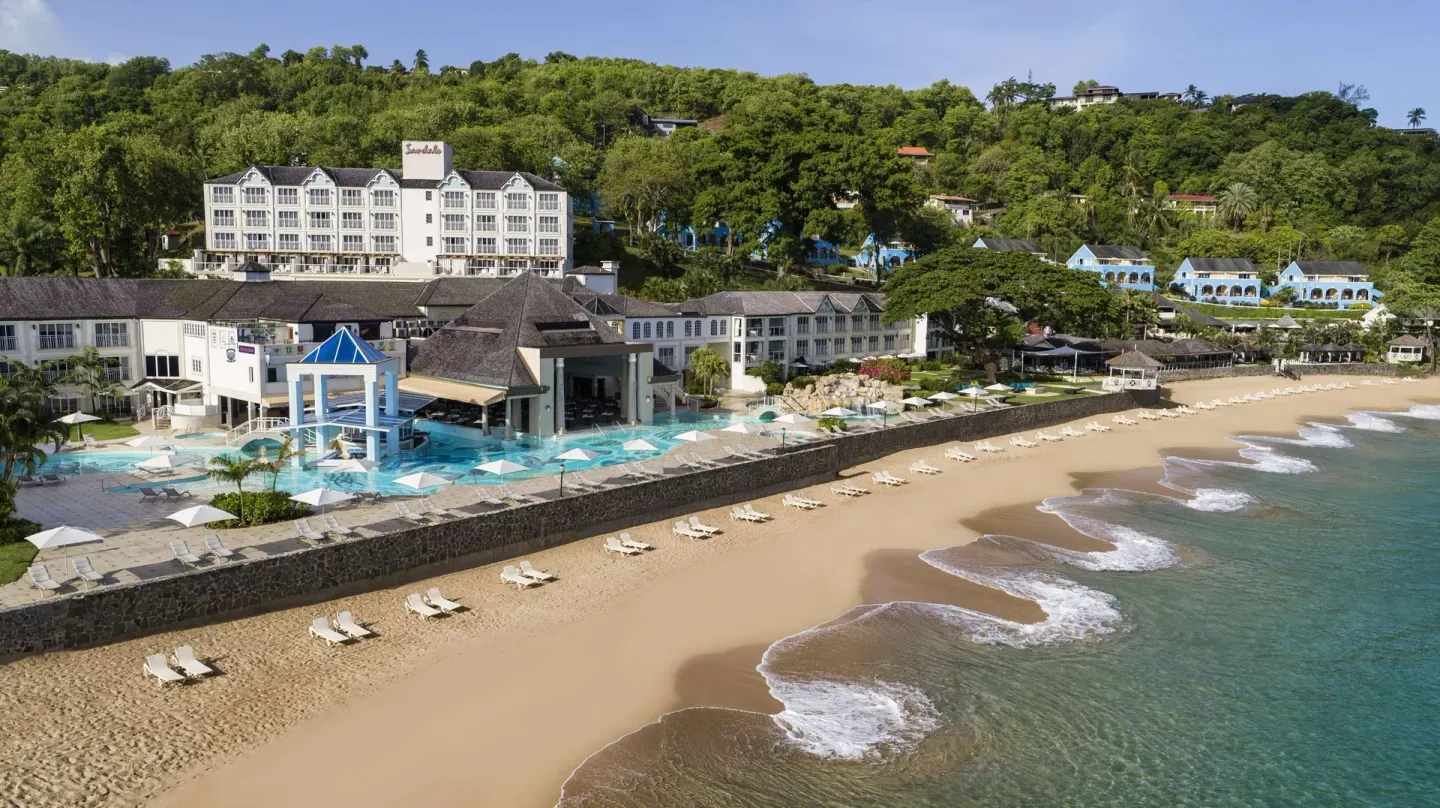 Aerial view of the beach, pool, and resort buildings at Sandals Regency La Toc.