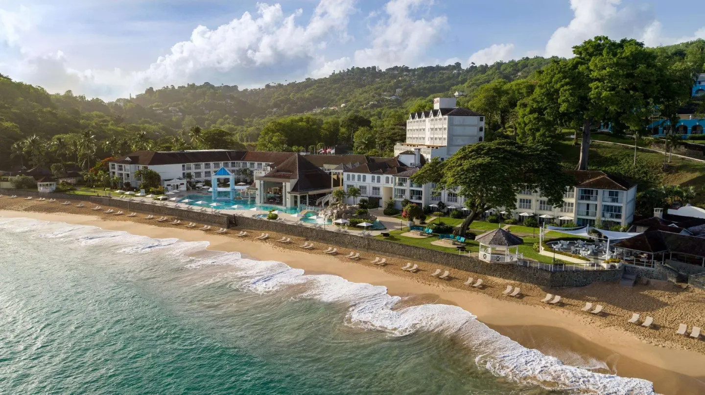 Aerial coastline view of resort buildings and beach at Sandals Regency La Toc.