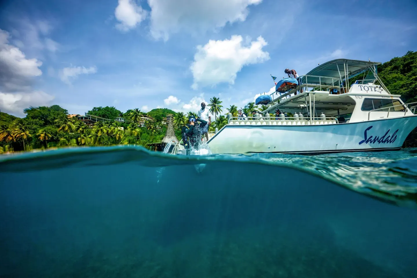 A dive boat and scuba diver at the waterline near Sandals Regency La Toc.