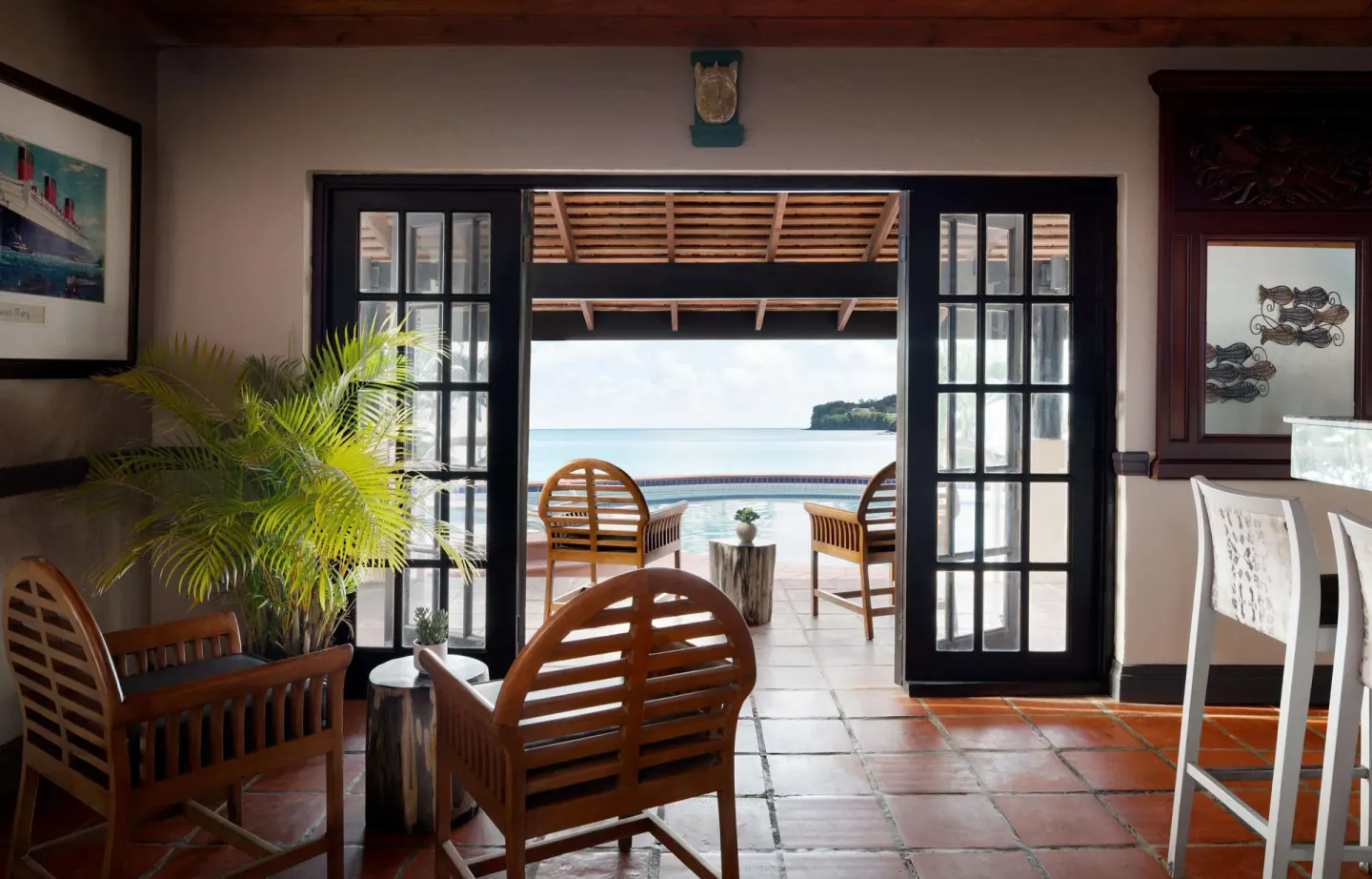 Lounge seating opening to a pool and ocean view at Sandals Regency La Toc.