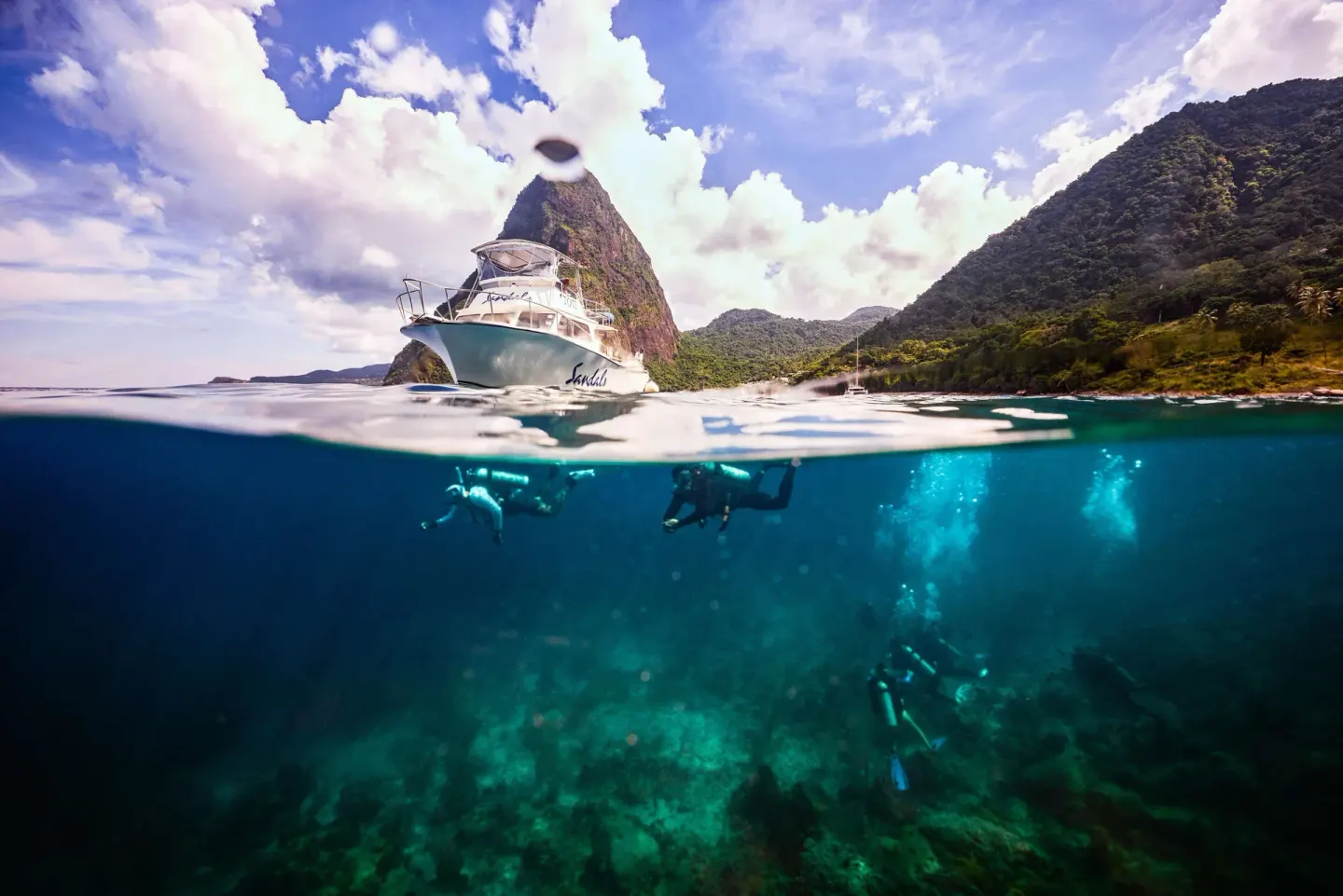 Dive boat and scuba divers in clear water near Sandals Regency La Toc.