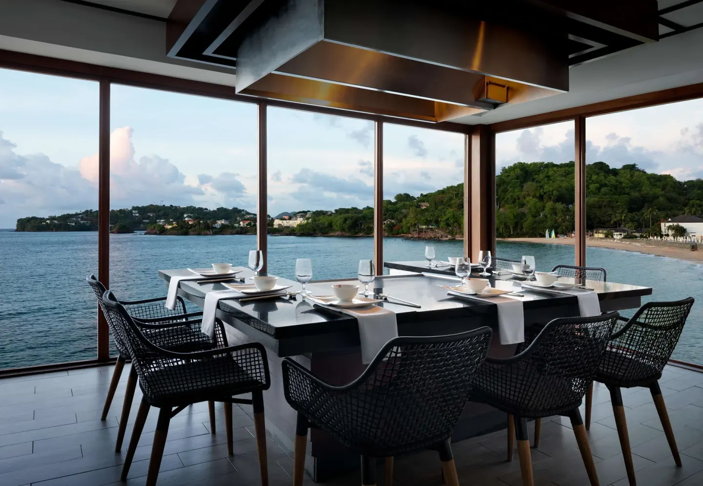 A teppanyaki table overlooks the bay through large windows at Sandals Regency La Toc.