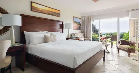 Club room with king bed and ocean-facing patio at Sandals Regency La Toc.