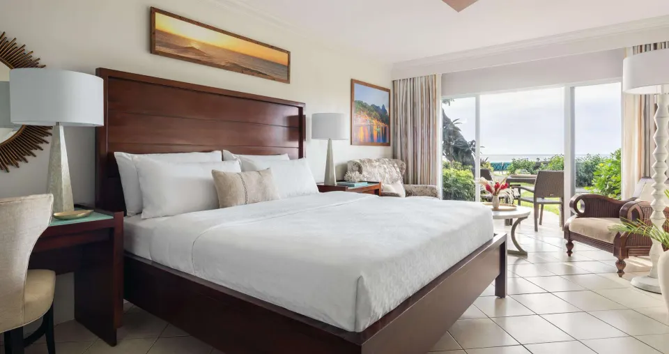 Club room with king bed and ocean-facing patio at Sandals Regency La Toc.