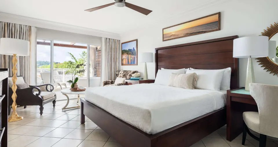 Club Level Terrace Junior Suite bedroom with king bed at Sandals Regency La Toc.