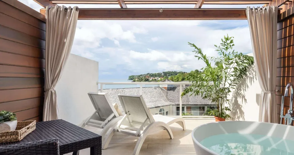 Ocean-view terrace with soaking tub and loungers at Sandals Regency La Toc.