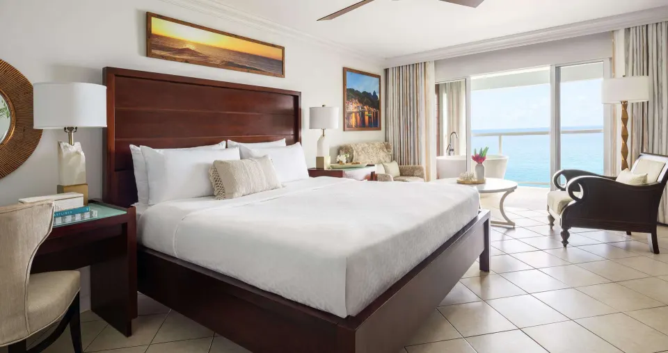 Ocean-view club suite bedroom with king bed at Sandals Regency La Toc.
