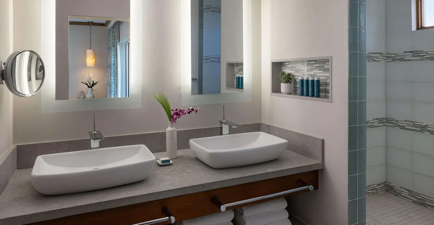 Double vanity and walk-in shower in a suite bathroom at Sandals Regency La Toc.